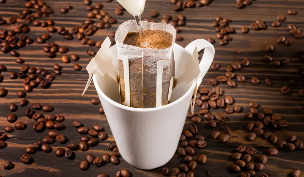 brewing coffee through filter with coffee beans around