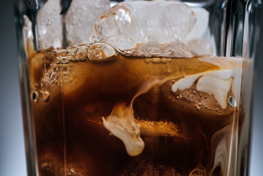 close up view of cold brewed coffee with ice cubes in glass