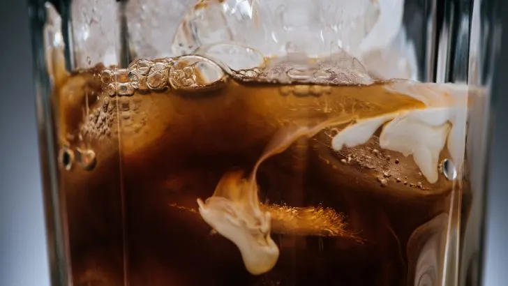 close up view of cold brewed coffee with ice cubes in glass