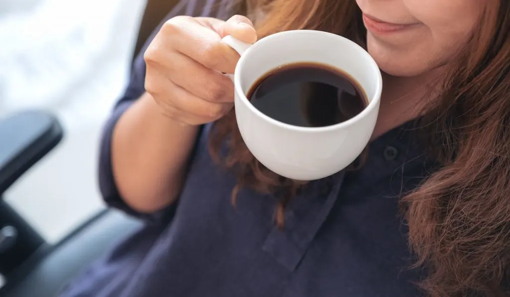 girl holding cup of coffee
