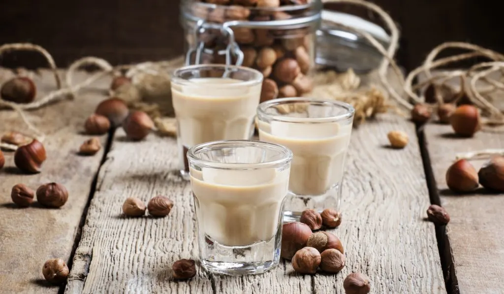 hazelnut milk and hazelnuts on the background