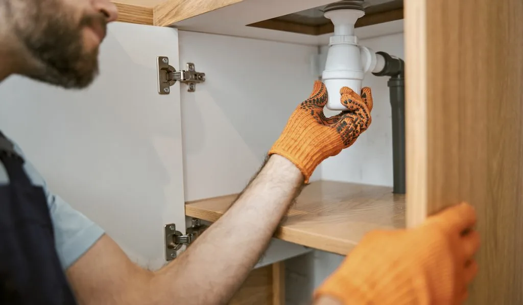 plumber removing drain pipe