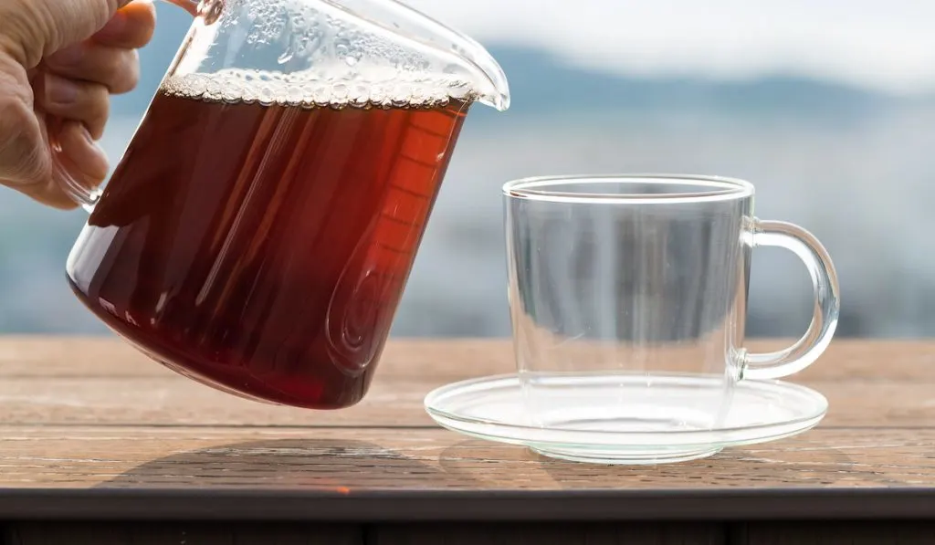 pouring coffee to an empty glass cup