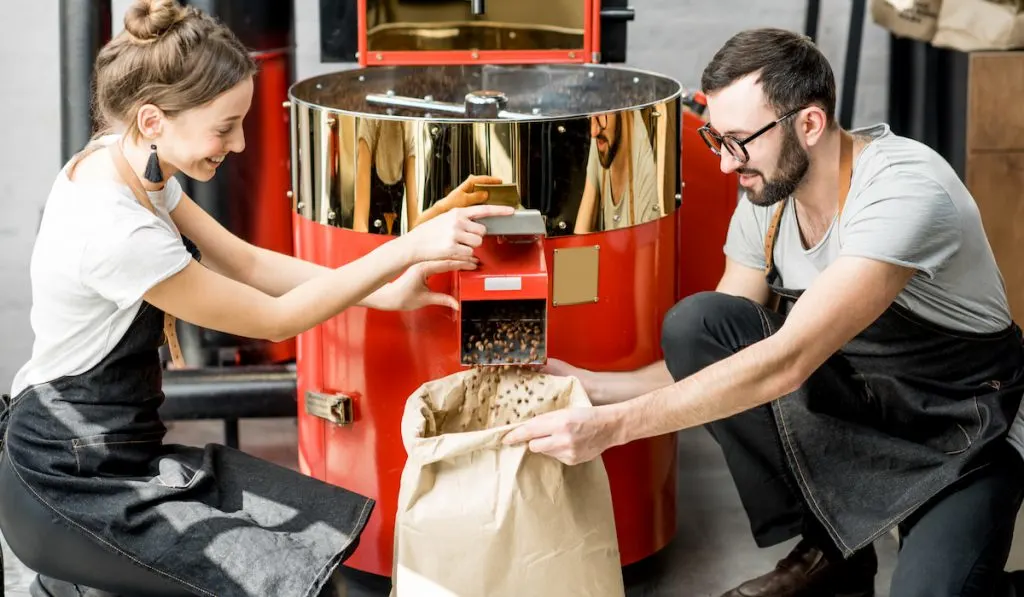 pouring roasted coffee beans in sack